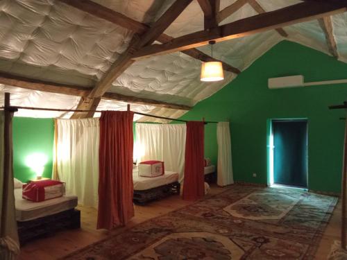 a room with two beds and a green wall at Chambres d'hôtes Les cabris in Verneix