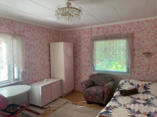 a bedroom with a bed and a dresser and a chair at Grandma’s house in Iisalmi