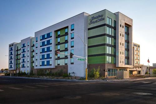 Hampton Inn & Suites Las Vegas Convention Center - No Resort Fee في لاس فيغاس: مبنى على زاوية شارع فيه إشارة مرور