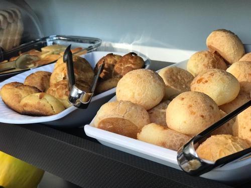 een tafel met twee schalen brood en borden met eten bij OP'S HOTEL in Serranópolis