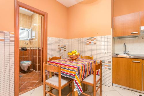 a kitchen with a table with a bowl of fruit on it at Apartments by the sea Tucepi, Makarska - 22384 in Tučepi