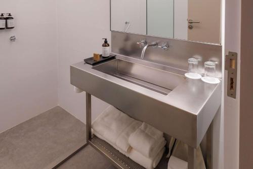 a bathroom with a sink with towels under it at Hualta Hotel Mendoza, Curio Collection by Hilton in Mendoza