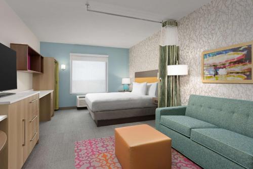 Habitación de hotel con cama y sofá en Home2 Suites By Hilton Durham University Medical Center, en Durham