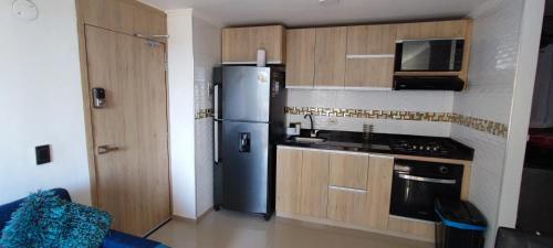 y cocina con nevera y microondas. en Apartamento vacacional en Santa Marta, en Santa Marta