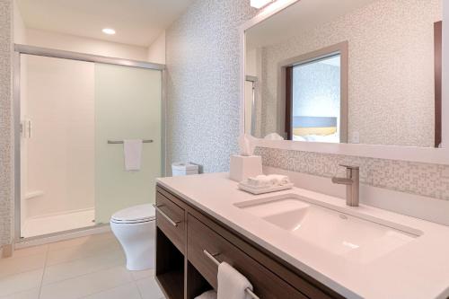 Home2 Suites By Hilton Alcoa Knoxville Airport في الكوا: حمام مع حوض ومرحاض ومرآة