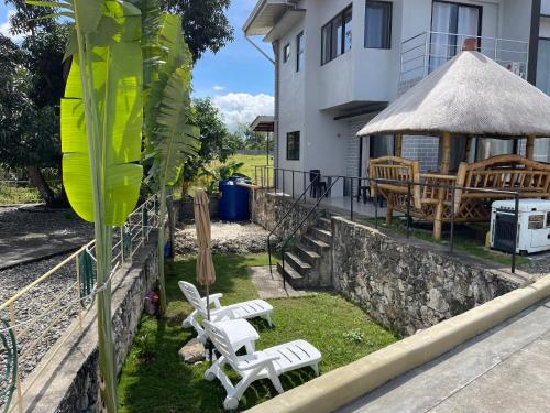 a yard with two white chairs and a gazebo at Mango Prima in Moalboal