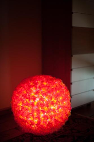 a large red ball is sitting on a floor at Nest on The Lake in Marone