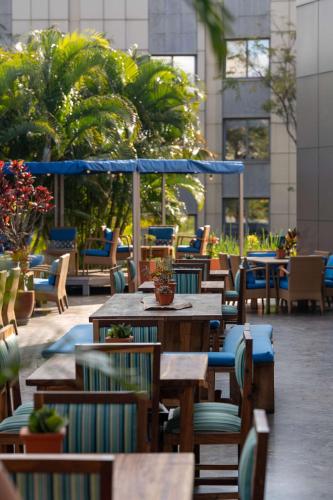 an outdoor restaurant with wooden tables and chairs at Radisson Blu Hotel Lusaka in Lusaka