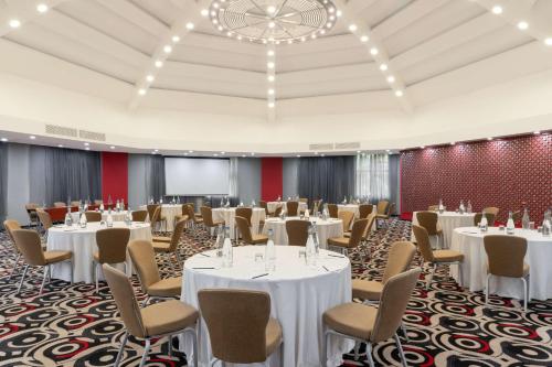 a conference room with tables and chairs and a projection screen at Radisson Blu Hotel Lusaka in Lusaka