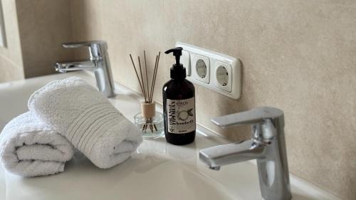 a bathroom sink with a towel and a bottle of soap at Ferienhaus Balsbergblick in Unterwössen