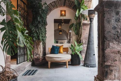 an archway with a bench on a patio with plants at Lovely house at the heart of San Miguel in San Miguel de Allende