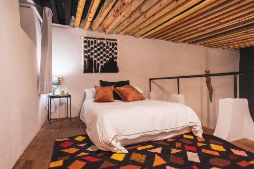 サンミゲル・デ・アジェンデにあるLovely house at the heart of San Miguelのベッドルーム1室(オレンジ色の枕が付いたベッド1台付)