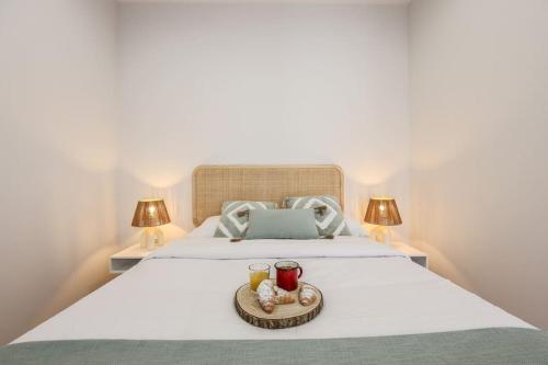 a bed with two glasses and a tray of food on it at Luxe apartments Madrid Rio by RentitUP in Madrid
