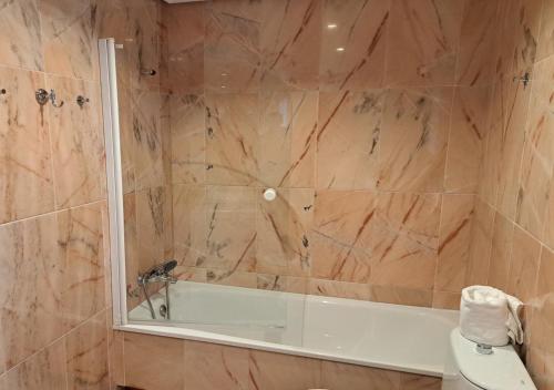 een badkamer met een douche, een bad en een toilet bij Encanto Urbano: Piso céntrico totalmente equipado in Lebrija