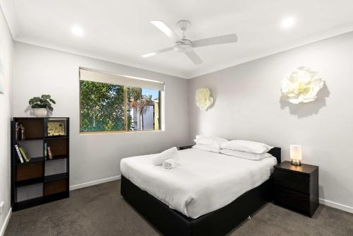 1 dormitorio con 1 cama y ventilador de techo en Charming 3-bed Apartment near Local Shops, en Brisbane