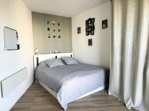- une chambre avec un lit et un rideau dans l'établissement Un nid douillet pour les JO, à Saint-Denis