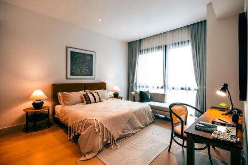 a bedroom with a bed and a desk and a window at ViiA Residence, Mid Valley KL in Kuala Lumpur