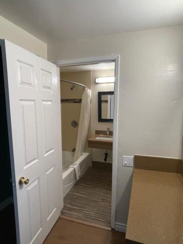 a bathroom with a tub and a sink and a door at Relax Inn in Los Angeles