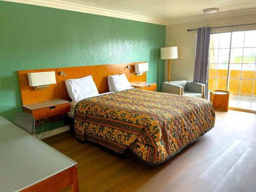 a hotel room with a bed and a green wall at Relax Inn in Los Angeles