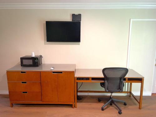a desk with a chair and a computer monitor on a wall at Relax Inn in Los Angeles