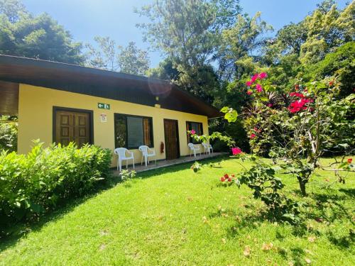 a house with a yard with chairs and flowers at La Purruja Lodge in Golfito