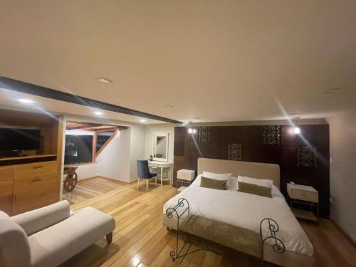 1 dormitorio con 1 cama y sala de estar en Hotel Ensueños en Cuenca