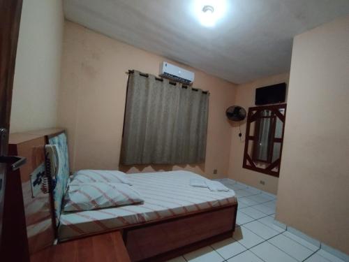 ein kleines Schlafzimmer mit einem Bett und einem Fenster in der Unterkunft Hotel novo sol santo amaro in São Paulo