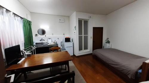 1 dormitorio con escritorio, 1 cama y escritorio sidx sidx sidx en Noah House 102貸切, en Shingu