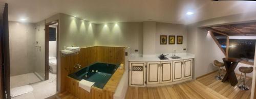y baño con bañera y lavamanos. en Hotel Ensueños, en Cuenca