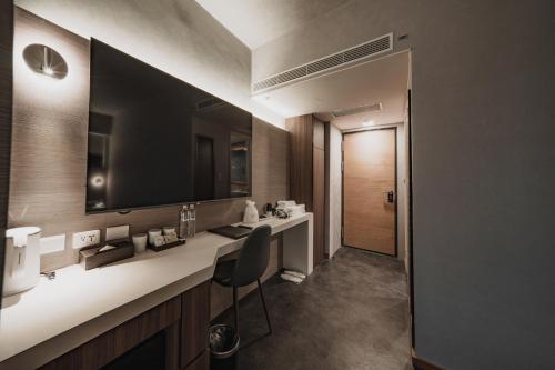 a bathroom with a sink and a mirror at Hub Hotel Kaohsiung Yisin Branch in Kaohsiung