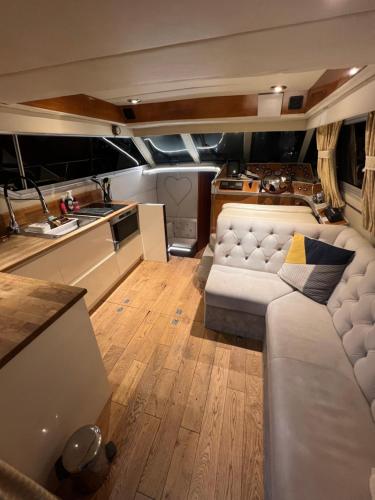 a living room with a couch and a kitchen at LUXURY 40 FOOT YACHT ON 5 STAR OCEAN VILLAGE MARINA SOUTHAMPTON - minutes away from city centre and cruise terminals - Free parking included in Southampton