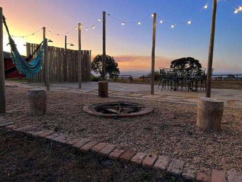 eine Terrasse mit einer Feuerstelle und einer Hängematte in der Unterkunft Rancho encontro dos sonhos in Carrancas