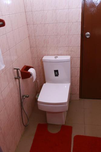 a bathroom with a toilet and a red rug at Oasis Colombo in Colombo