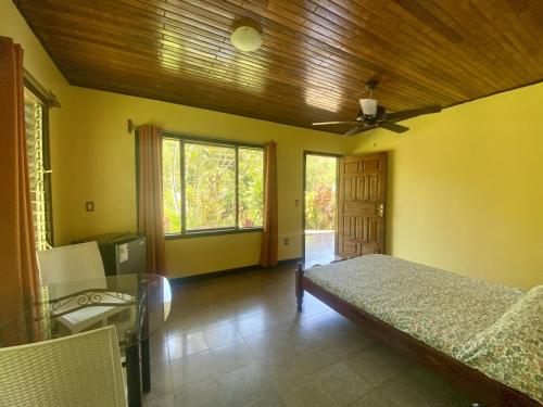 1 dormitorio con cama y techo de madera en La Purruja Lodge, en Golfito
