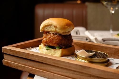 a sandwich in a wooden tray on a table at Novotel Sydney City Centre in Sydney