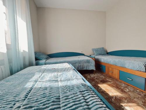 a room with three beds and a window at Casa rural el Retiro de Sancho in Cózar
