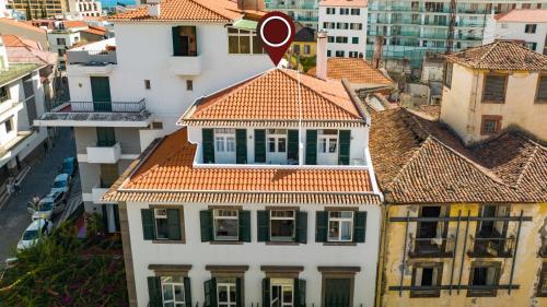 une vue sur un bâtiment blanc avec un toit rouge dans l'établissement Alojamento Local Trigal, à Funchal