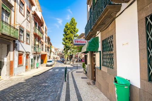une rue pavée dans une ville avec des bâtiments dans l'établissement Alojamento Local Trigal, à Funchal