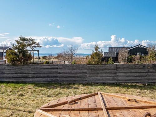 a wooden table in a field next to a fence at 4 star holiday home in Løgstør-By Traum in Løgsted