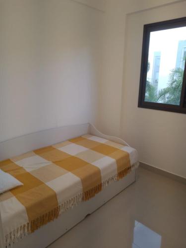 a bed sitting in a room with a window at Praia Mansa Caiobá 3 quartos in Matinhos