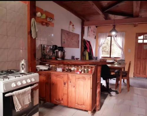uma cozinha com um fogão e uma mesa em Mi casita.envla em Villa La Angostura
