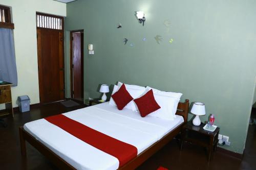 a bedroom with a bed with red and white pillows at Oasis Colombo in Colombo