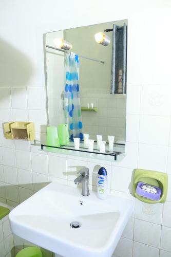a white bathroom with a sink and a mirror at Oasis Colombo in Colombo