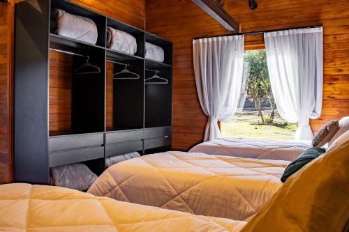 a bedroom with two beds and a window at Villa Vida. Sua cabana entre Urubici e São Joaquim - Serra Catarinense in São Joaquim