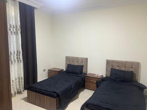 Elegant apartments for rent. في عمّان: غرفة نوم بسريرين مع وسائد زرقاء
