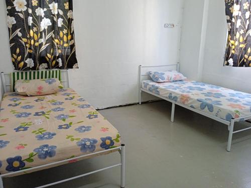 een kamer met 2 bedden in een kamer bij Homestay Indrawasih with 2 Bedroom in Perai