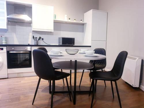 a kitchen with a table and chairs in a kitchen at Kelham Island - City Centre - Stylish - 2 BD - Free On-street Parking - Netflix - Fast WiFi in Sheffield