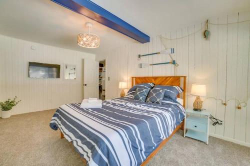 1 dormitorio con 1 cama con edredón azul y blanco en Redwood Retreat by the Lake, en Oscoda