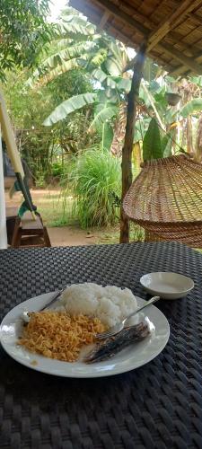 een bord eten op een tafel met rijst bij Paradise Surf in Dapa