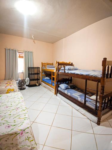 a room with two bunk beds and a tiled floor at Sítio Bosque das Palmeiras in Papucaia